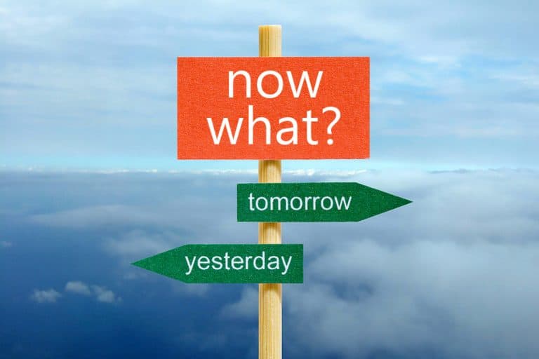 Roadsign that says now what with arrows pointing to yesterday and tomorrow